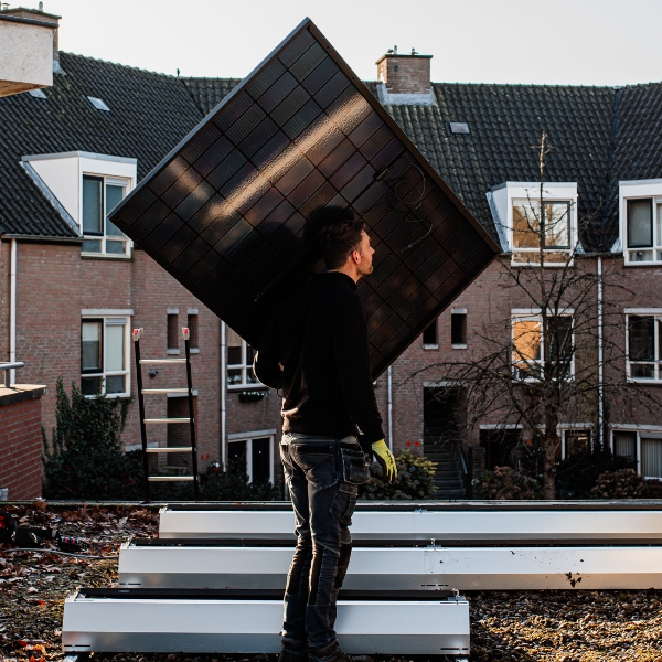 Particuliere zonnepanelen worden door Marco van Wattpiek op het dak getild.
